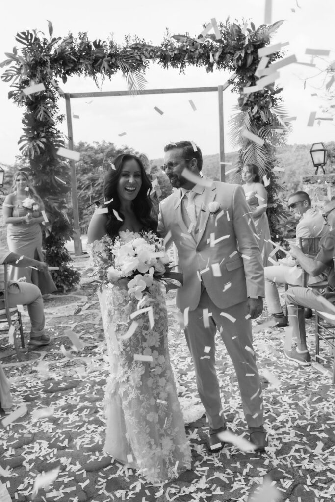 Intimate wedding ceremony with tropical florals and guests celebrating in a beautiful outdoor setting.