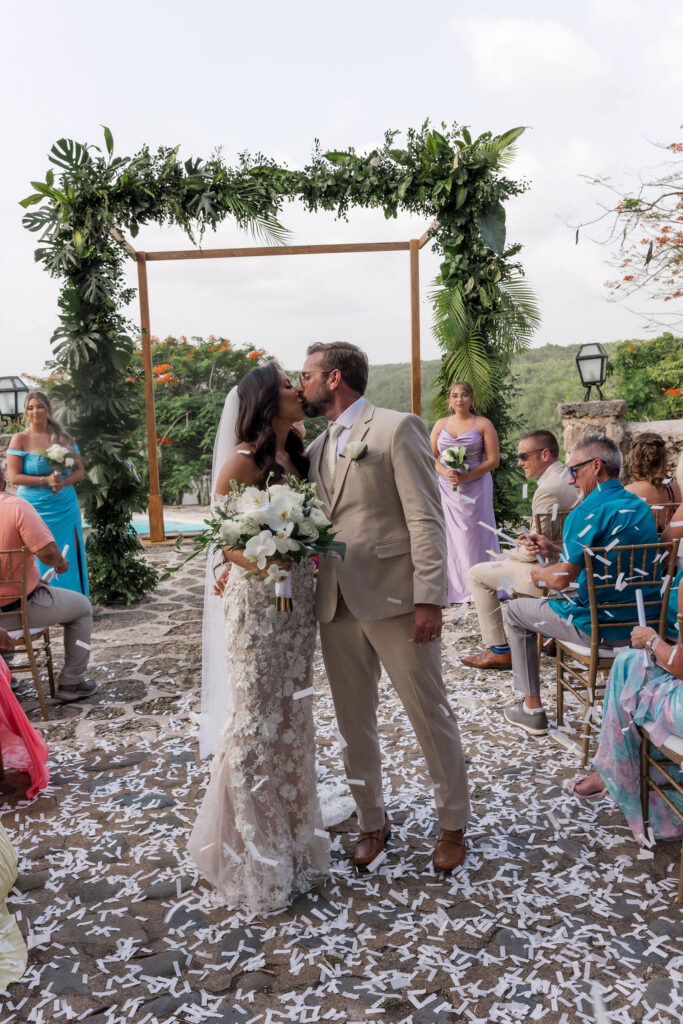 Intimate wedding ceremony with tropical florals and guests celebrating in a beautiful outdoor setting.