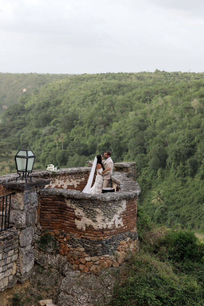 Bride and groom walking through a charming Mediterranean-style village during their destination wedding weekend.