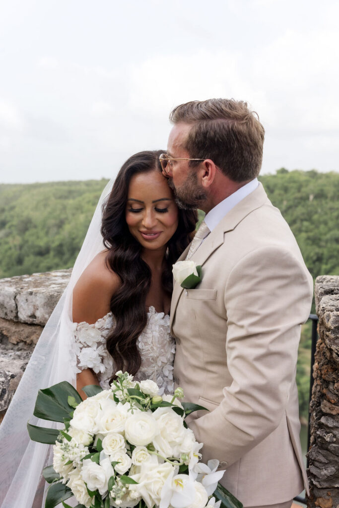 Bride and groom walking through a charming Mediterranean-style village during their destination wedding weekend.